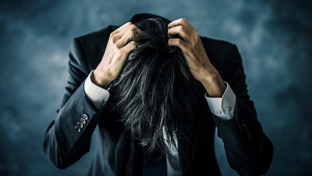 頭を抱える男性
